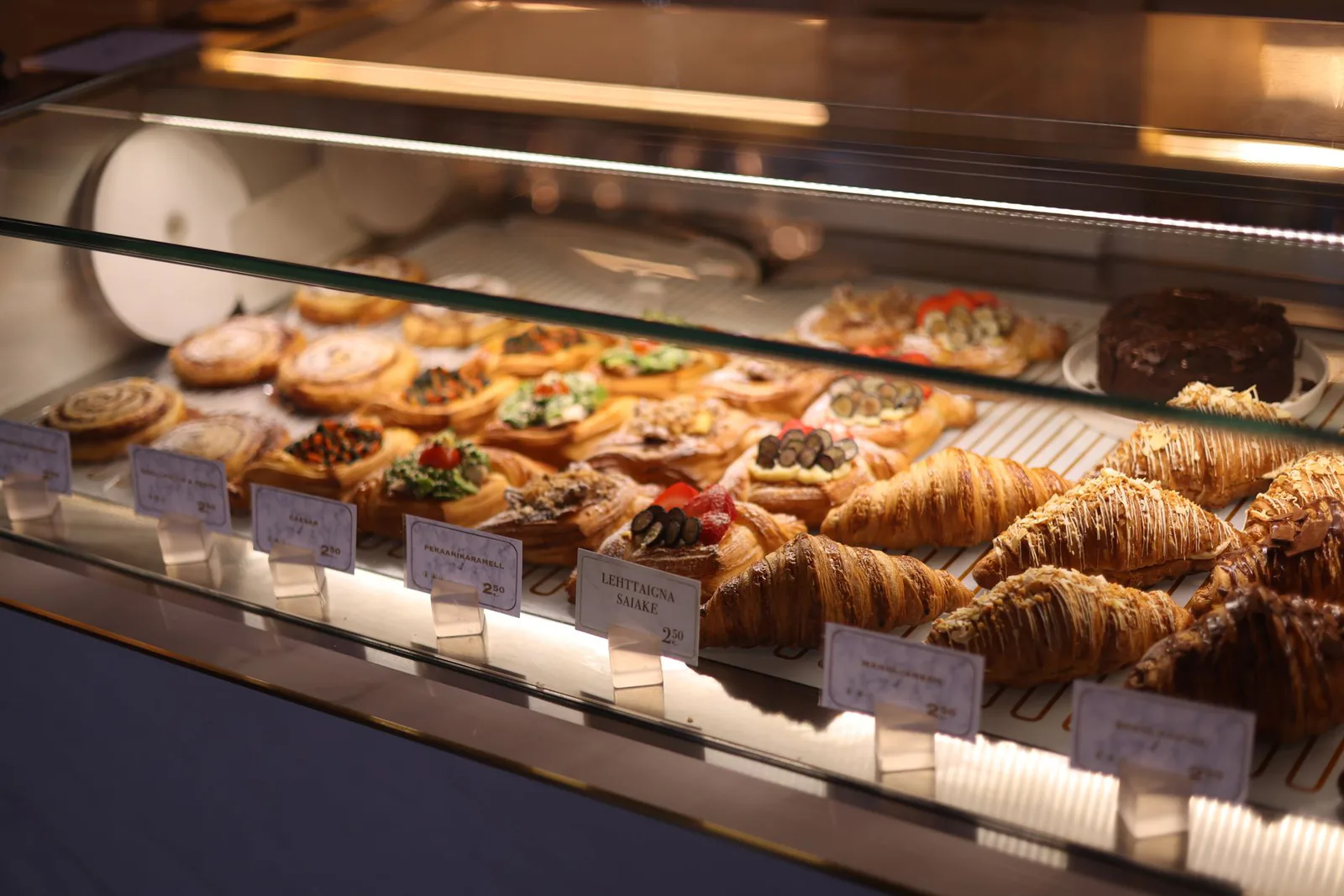 Assorted pastries and croissants in bakery display case